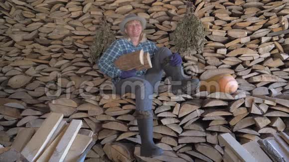 快乐的女人坐在一堆木柴上拿着一堆木柴视频的预览图