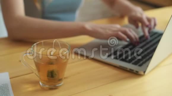 一个女人用热水把茶袋浸入杯子里的特写镜头年轻的女人喝茶紧紧抓住女孩手视频的预览图