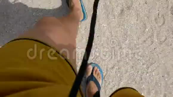 在沙滩上散步人穿黄色短裤的腿的俯视图视频的预览图