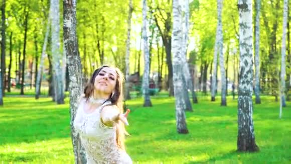 阳光洒在绿色公园里穿着性感服装跳舞的美女身上视频的预览图