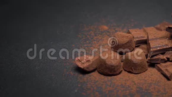 深色或牛奶有机巧克力可可粉和深色混凝土背景的松露糖果视频的预览图