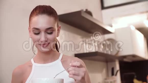 漂亮的女人在厨房的特写镜头里吃着碗里的食物视频的预览图