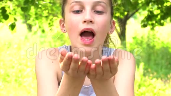 嬉戏的女孩用手吹着闪光的慢动作视频的预览图