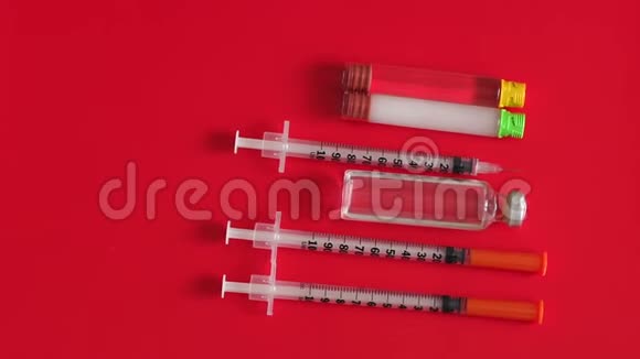 胰岛素注射器和安瓿的胰岛素红色背景特写视频的预览图