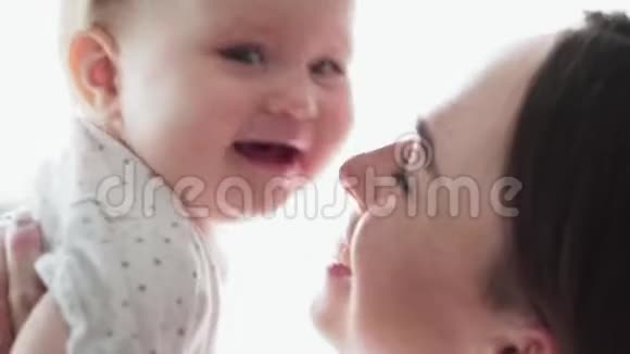 可爱的妈妈和快乐的小宝宝玩耍亲吻和微笑视频的预览图