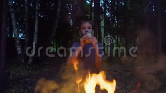 暑假期间可爱的男孩在树林里的房子旁吃着美味的三明治视频的预览图