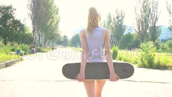 少女在阳光下慢悠悠地走着滑板视频的预览图