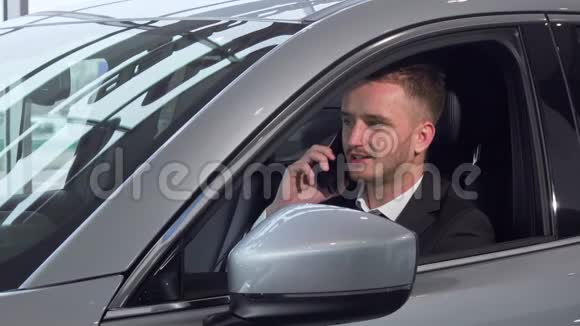 商人坐在一辆新汽车上打电话视频的预览图