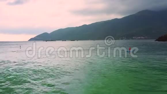 在海上划桨的女子剪影在丘陵海岸上视频的预览图