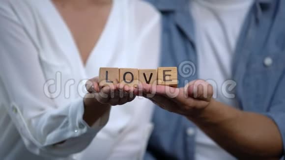 男人和女人把爱的词放在木头上家庭关系的概念视频的预览图
