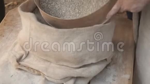 米勒筛出全麦面粉一个女人用木筛把谷物从面粉中分离出来视频的预览图