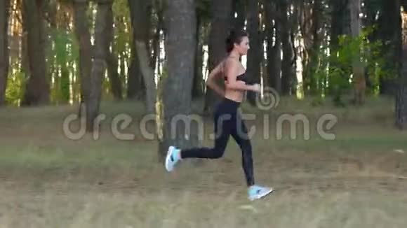 运动的女人穿过秋天的森林慢动作视频的预览图