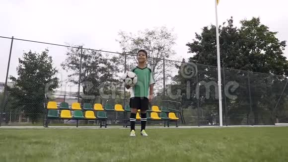 快乐的男孩拿着足球看着镜头视频的预览图