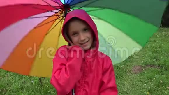 雨中的孩子下雨天在公园里玩户外女孩旋转伞视频的预览图