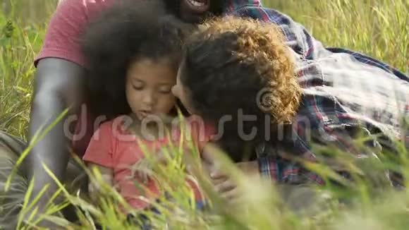 年轻的母亲亲吻拥抱领养的女儿幸福的多种族家庭视频的预览图