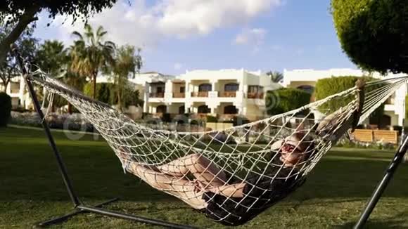 日落时分女人在吊床上发冷度假和放松自然和娱乐视频的预览图