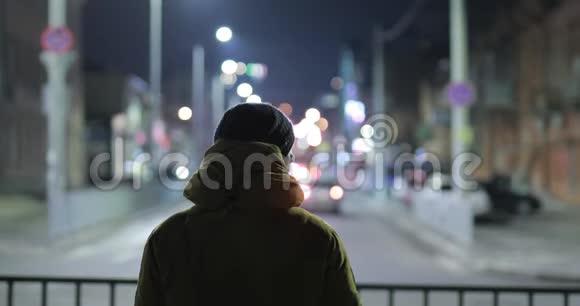 不可辨认的男人在夜间听耳机音乐视频的预览图