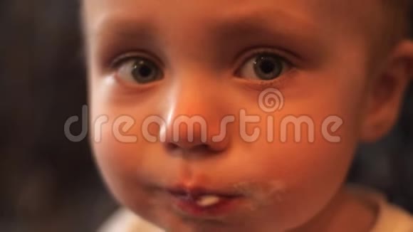 一张小男孩的肖像他吃着白色香草冰淇淋脸上涂着冰淇淋男孩看起来很像视频的预览图