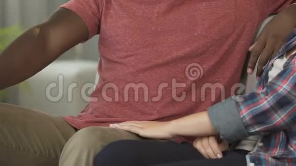 非裔美国人的丈夫拥抱他漂亮的妻子在家里一起放松爱视频的预览图