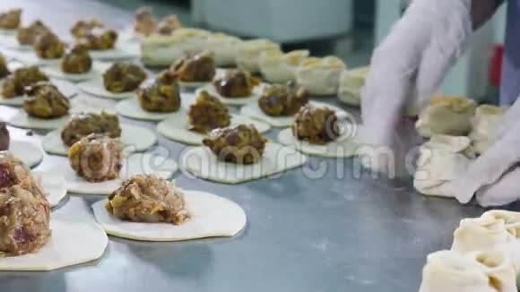包饺子穿白色乳胶手套的女工用面团包肉包饺子肉类工厂关门视频的预览图