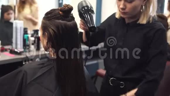 发廊上幸福女人的肖像专业发型造型理念理发师吹干头发的女孩视频的预览图