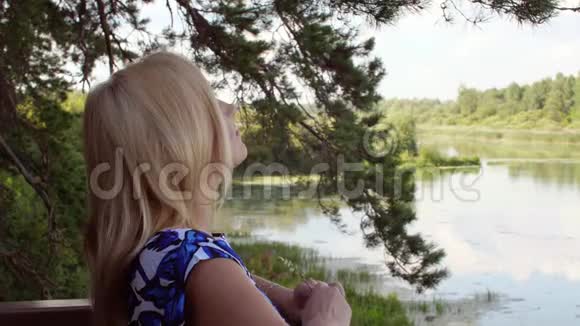 夏日森林背景池塘景观中的美女视频的预览图