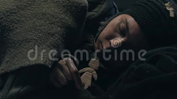 无家可归的少年抱着小纸男难民梦想着家庭和家视频的预览图