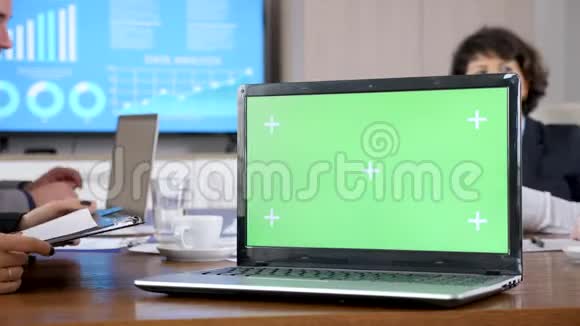 会议室桌子上有绿色屏幕色度模拟计算机视频的预览图