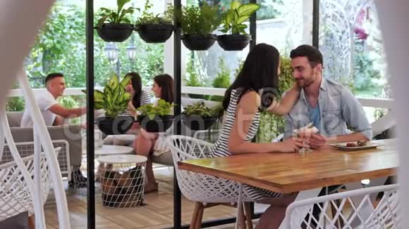 对幸福的夫妇在咖啡馆吃甜点可爱的情侣在咖啡馆拥抱视频的预览图