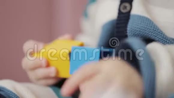 一岁的小男孩正在玩彩色塑料砖乐高快乐的小宝宝玩五颜六色的乐高视频的预览图