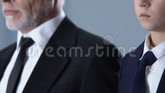 优雅的男孩和祖父穿着西装调整领带穿着正式的衣服视频的预览图
