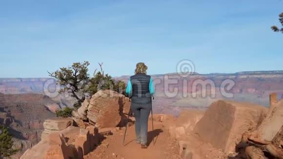 女人徒步到小径爬上石头休息欣赏风景视频的预览图