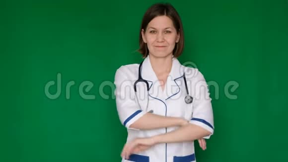 微笑自信的女医生穿着实验室外套看着绿色屏幕上的相机Chroma键关门视频的预览图