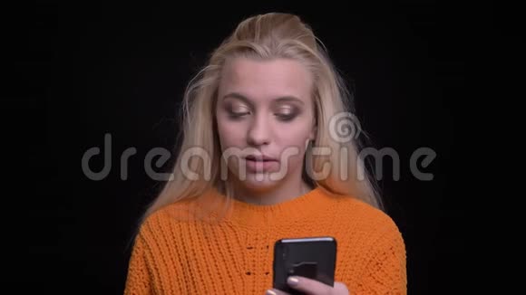 年轻美丽的白种人女性通过电话浏览网页并对社交媒体帖子做出反应的特写镜头视频的预览图