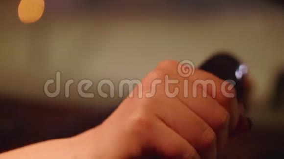 女孩双手用深色指甲指着方向盘背景模糊的灯光视频的预览图
