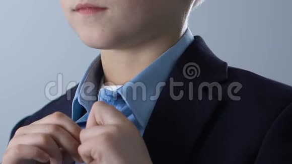 可爱的男孩扣上蓝色衬衫准备上学儿童时尚视频的预览图