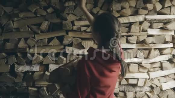 女人把生柴放在柴堆里视频的预览图