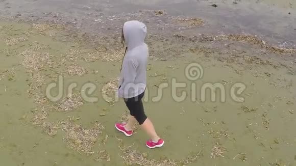 孤独的女人走在空荡荡的海岸线上思考生活抑郁视频的预览图