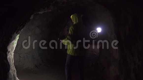 一个手电筒的志愿者正在黑暗的山洞里寻找一个人慢悠悠视频的预览图
