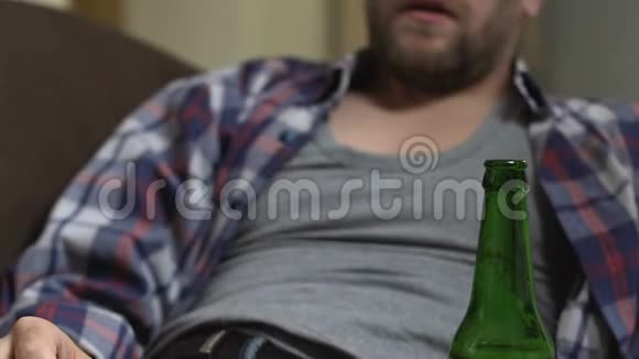 坐在沙发上喝啤酒的醉汉瘾君子视频的预览图