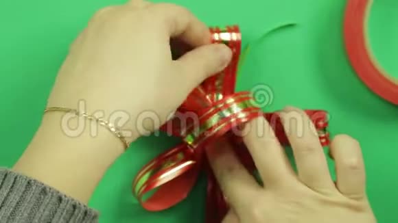 绿色背景上闪亮的红色缎带礼品蝴蝶结视频的预览图