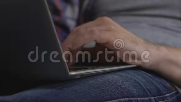 男性手滚动手提触摸板在家上网自由职业视频的预览图