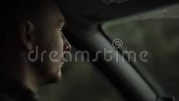 一个成年男子驾驶汽车的特写最后的黑暗视频的预览图