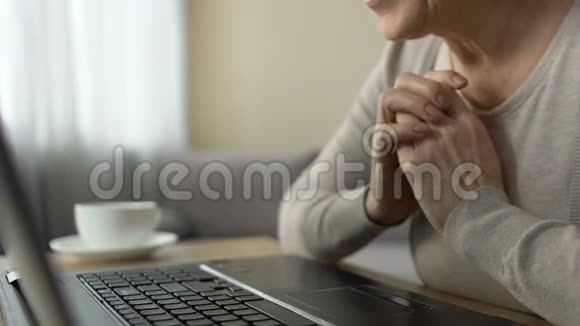 快乐的女人在笔记本电脑互联网上看到她成年孙子的照片视频的预览图