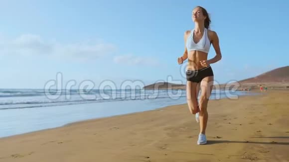 女子运动员剪影在海滩上奔跑冲刺海浪在海边的早晨背景上坠毁下面的运动步骤视频的预览图