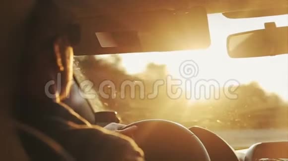 一个戴太阳镜的成年人白天开车的近景明亮的阳光照在他的眼睛里视频的预览图