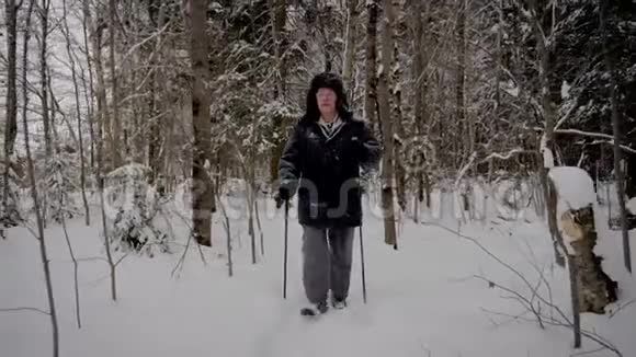 运动中的人在冬天用跋涉穿越白雪森林视频的预览图