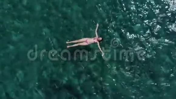空中年轻女子在碧蓝的海面上放松视频的预览图