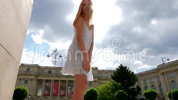穿着夏装的红发美女斜靠在阳光下的镜头前视频的预览图