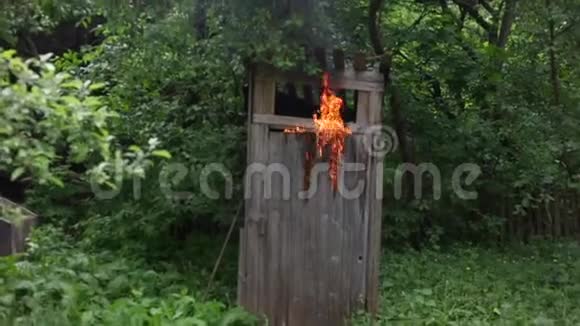 一个年轻人从着火的乡村厕所里出来试图用灭火器灭火一片燃烧视频的预览图